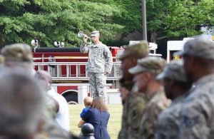 The Memorial Day Observance involves a roll call of the names and hometowns of the 42 individuals who have lost their lives in service to this county. Following the roll call, a bugler plays Taps. Nearby, a child, wrapped in a loving embrace, quietly looks on. Georgia State Defense Force photo by Pfc. Davidson | Released